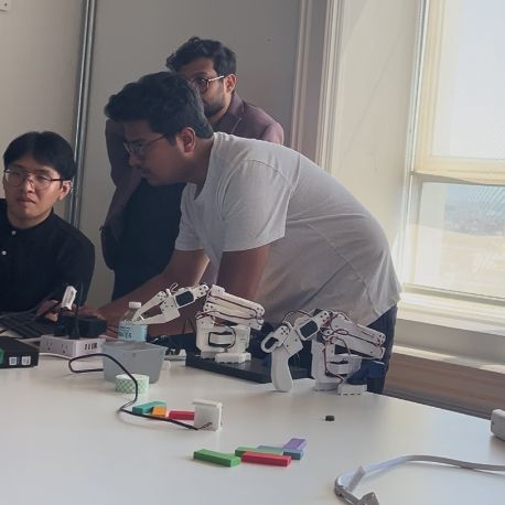 Builders showcasing robotic hardware and dexterous hands at the summit