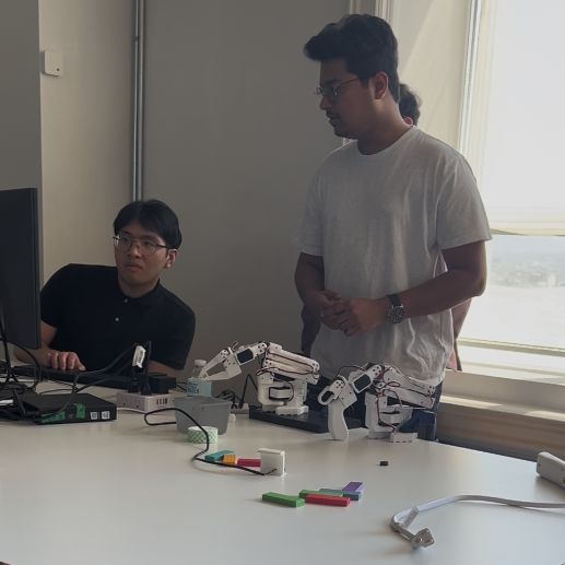 Engineers demonstrating robotic hands and physical AI hardware at the Physical AI Shift Summit